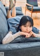 A woman laying on a couch with her legs crossed.