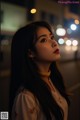 A woman with long black hair standing in the middle of a street.