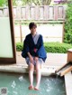 A woman in a blue kimono sitting in a pool of water.