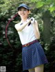 A woman in a polka dot skirt holding a golf club.