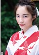 A woman in a red and white kimono posing for a picture.