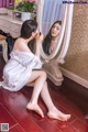 A woman sitting on the floor in front of a mirror.